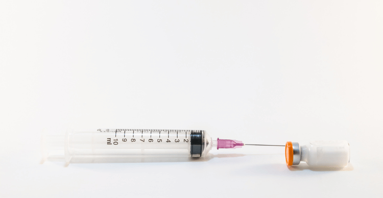 A syringe with an attached filter on a white background.