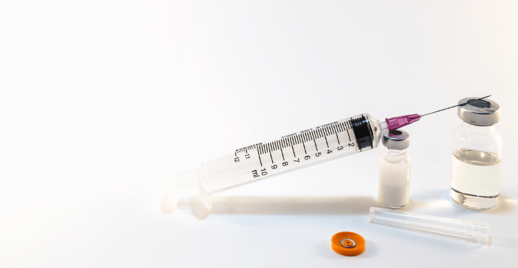 A syringe with a filter and vials on a white background.