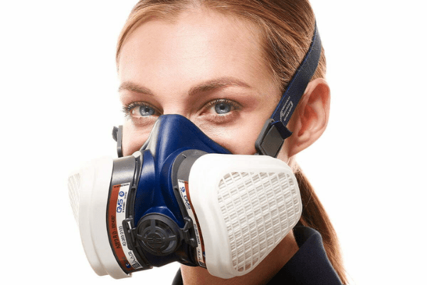 Close-up of a woman wearing a blue and white respirator mask.